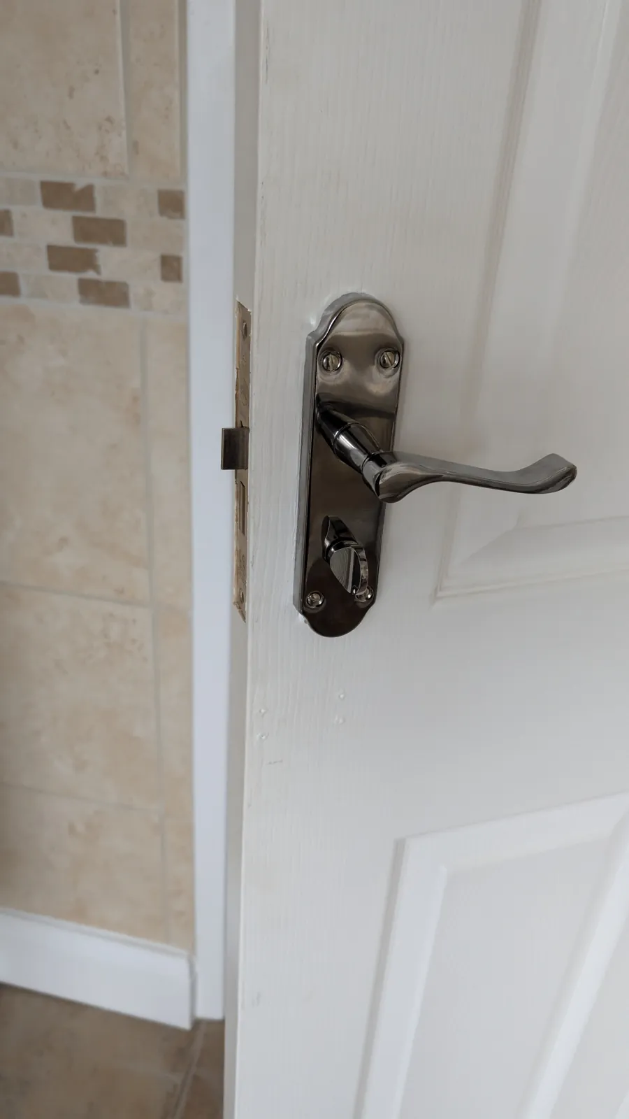 Chrome lever handle and lock fitted to an internal door